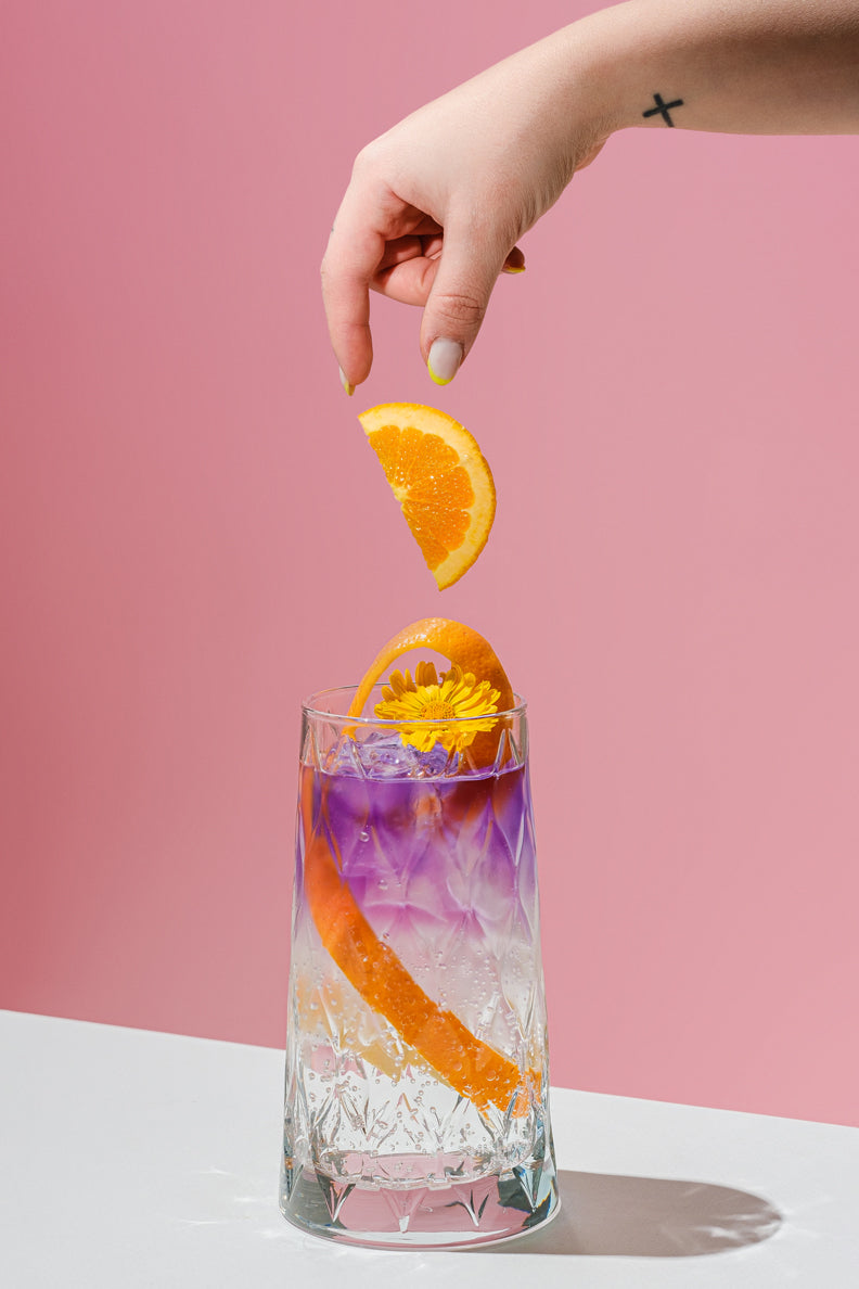 Litmus Spritz cambiando de color en copa con naranja y hielo