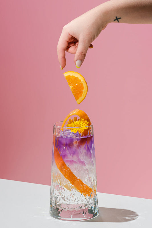 Litmus Spritz cambiando de color en copa con naranja y hielo